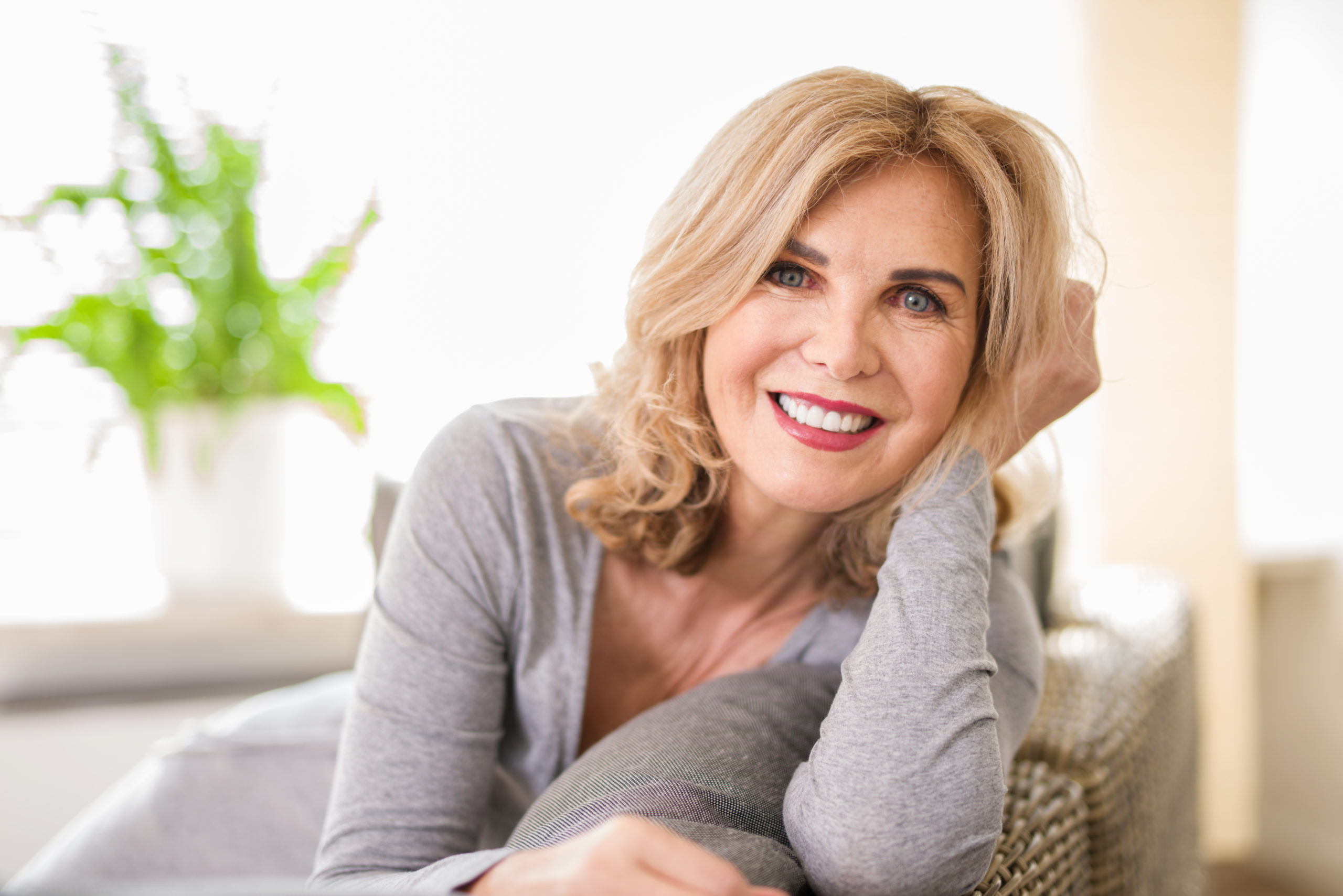 menopausal age woman smiling on a couch